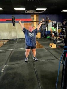 Photo of a woman lifting a heavy barbell overhead